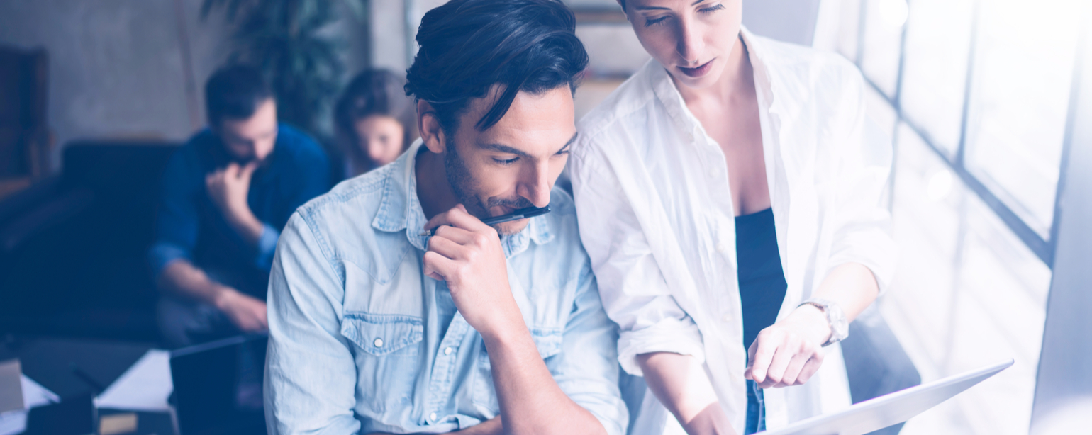 Coworkers reviewing data on a tablet in office